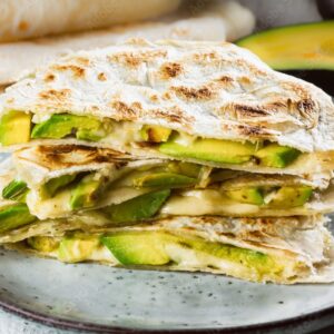 Stack of breakfast quesadillas with avocados