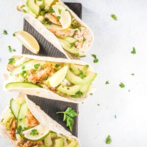 Three breakfast tacos with limes and lemons