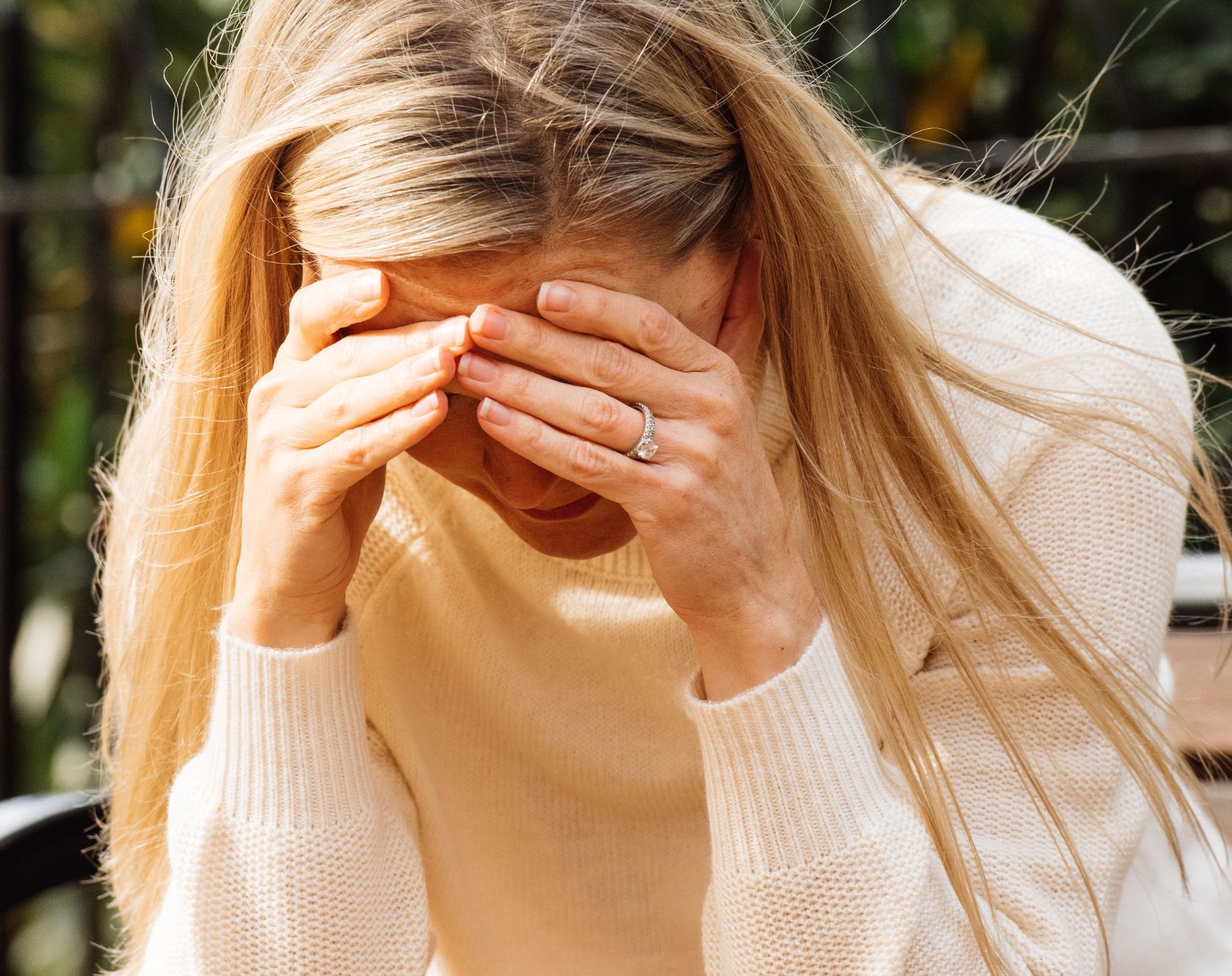 Image showing a person sitting with their head in their hands, representing the overwhelming feelings when realizing they have Multiple Sclerosis and how symptoms like trigeminal neuralgia led to diagnosis.