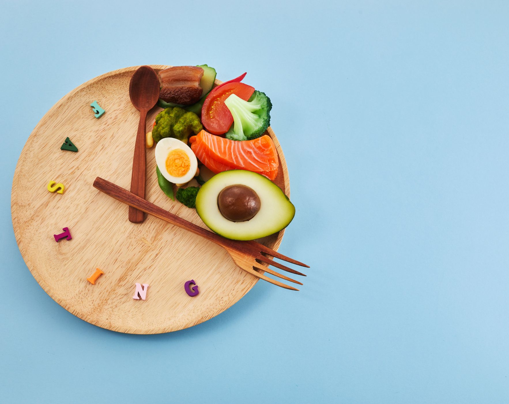 A clock showing fasting hours and a healthy meal, symbolizing the practice of intermittent fasting and its potential benefits for Multiple Sclerosis.
