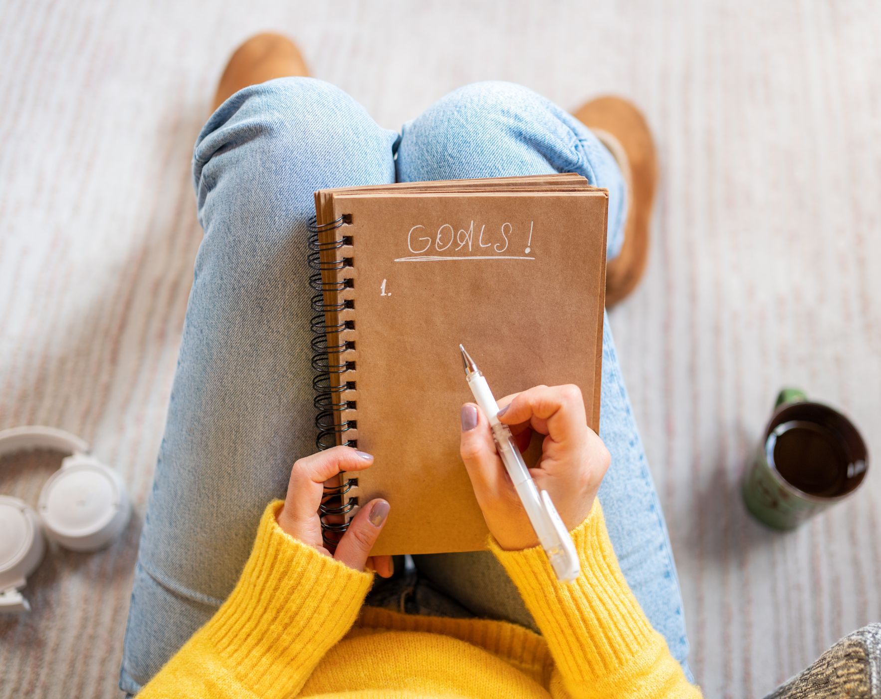 Woman writing New Year goals in a journal while living with MS and focusing on small habits.